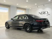 The gloss black Mercedes-Benz S 450 4MATIC is elegantly parked in a showroom in Alicante, Spain, showcasing its sleek rear three-quarter profile.