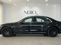 The sleek black Mercedes-Benz S 450 4MATIC luxury sedan is showcased from its side profile in a modern Alicante showroom.
