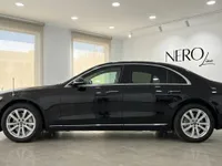 黒いメルセデス・ベンツ S 680 ガード装甲車が、マドリードの明るいショールームで側面から撮影されています。