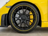 العجلة الأمامية لسيارة بورش 718 كايمان GT4 RS الصفراء في أليكانتي، تتميز بجنوط سوداء بلمسات صفراء ومكابح صفراء بارزة.