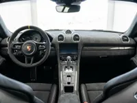 منظر داخلي لسيارة بورش 718 كايمان GT4 RS في أليكانتي، يعرض لوحة القيادة وعجلة القيادة والكونسول الوسطي.