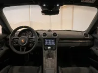 The luxurious interior of the 2023 Porsche 718 Cayman GT4 RS, showing the dashboard, steering wheel, and center console in Zurich.