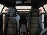 The interior of the Porsche 718 Cayman GT4 RS in Zurich, featuring black leather Weissach RS bucket seats and light grey seatbelts.