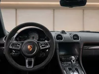 The detailed interior of the 2021 Porsche 718 Spyder in Zurich, showing the sporty steering wheel, dashboard, and infotainment system.