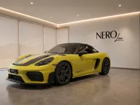 The yellow 2024 Porsche 718 Spyder RS convertible, showcasing its sleek front-three-quarter view in a showroom in Zurich.