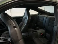 The luxurious interior of the Porsche 911 Carrera 4 GTS Aerokit in Zurich, showing the black leather front passenger seat and rear seats.