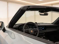 The sleek interior of the Porsche 911 Carrera 4 GTS Cabriolet in Zurich, showing the steering wheel, dashboard, and infotainment system.