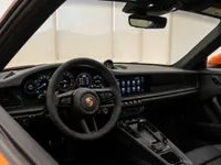 View of the Porsche 911 Carrera 4S cockpit in Lausanne, featuring the steering wheel, digital dashboard, and infotainment screen.