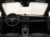 The luxurious interior of the Porsche 911 Carrera 4S in Lausanne, featuring its modern dashboard, steering wheel, and central console.