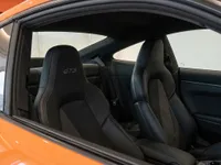 View of the black leather and Alcantara GTS sports seats inside the orange Porsche 911 Carrera 4S in Lausanne.