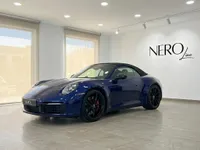 سيارة بورش 911 كاريرا 4S كابريو الزرقاء موديل 2022 متوقفة في الداخل، تعرض تصميمها الأنيق وسقفها القماشي الأسود في إيبيزا.