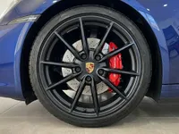 العجلة الأمامية لبورش 911 كاريرا 4S كابريو مع جنط أسود متعدد الأضلاع ومكابح حمراء، متوفرة في إيبيزا.