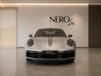 The 2023 Porsche 911 Carrera T in gloss GT Silver Metallic, presented head-on in a showroom in Zurich.