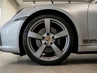 The front wheel and fender of the gloss GT Silver Metallic Porsche 911 Carrera T in Zurich, showcasing its elegant design.