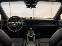 The luxurious interior of the Porsche 911 Carrera T in Zurich, showcasing the dashboard, steering wheel, and front seats.