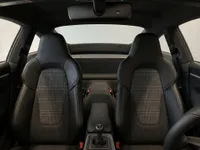 A detailed view of the Porsche 911 Carrera T interior in Zurich, showing the black leather sport seats with houndstooth inserts and the manual gear shifter.