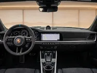 The luxurious interior of the Porsche 911 Dakar in Zurich, featuring its advanced dashboard, steering wheel, and central infotainment screen.