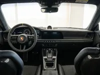 The luxurious cockpit of the Porsche 911 GT3 in Lausanne, featuring its Alcantara steering wheel, modern dashboard, and carbon fiber bucket seats.