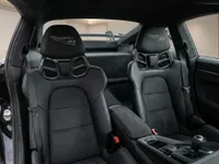 Porsche 911 GT3 interior showing black leather sport seats with Weissach RS logo, manual transmission, and roll bar in Lausanne.