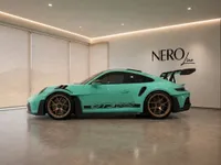 The Gloss Mint Green Porsche 911 GT3 RS is displayed from its left side profile in a modern Zurich showroom.