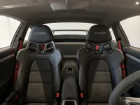 The interior of the Porsche 911 GT3 RS in Zurich, showcasing its black sports seats with GT3 RS embroidery and red seatbelts.