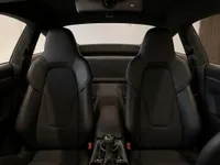 The image shows the luxurious black leather interior of the Porsche 911 GT3 Touring, featuring the front seats and center console in Lausanne.