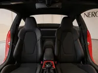 The interior of the Porsche 911 GT3 Touring in Zurich, featuring black sports seats with red stitching and the central console.