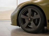 Porsche 911 Spirit 70 in satin Olive Green, showing a close-up of the front wheel and fender in Zurich.