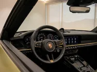 The luxurious interior of the Porsche 911 Spirit 70 in Zurich, showcasing the steering wheel, dashboard, and infotainment screen with golden accents.