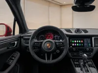 The interior of the Porsche Macan GTS in Lausanne, featuring the steering wheel, dashboard, and infotainment system.