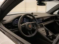 View of the luxurious Porsche Panamera 4S E-Hybrid cockpit in Lausanne, featuring the steering wheel, digital dashboard, and infotainment screen.