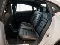 The spacious rear black leather seats of the Porsche Taycan are visible from the open passenger door in Lausanne.