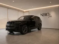 A sleek gloss black 2023 Land Rover Range Rover Sport is displayed in a modern showroom in Lausanne, seen from the front three-quarter angle.