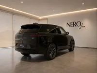 The black 2023 Land Rover Range Rover Sport is parked in a showroom in Lausanne, viewed from the rear three-quarter angle.