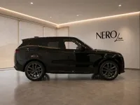 The sleek gloss black 2023 Land Rover Range Rover Sport is parked in a modern showroom in Lausanne.