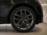 The gloss black Land Rover Range Rover Sport's front wheel and fender are prominently displayed in Lausanne.