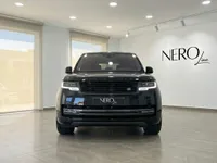 黒いレンジローバー ヴォーグ オートバイオグラフィー2023がマドリードのショールームに正面から駐車されており、その堂々としたフロントグリルが際立っています。