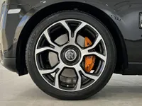 イビサにあるロールス・ロイス カリナンの前輪のクローズアップ。黒とシルバーのスポーク、鮮やかなオレンジ色のブレーキキャリパーが特徴です。