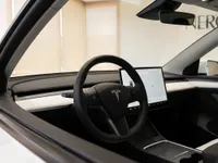 The interior of the 2021 Tesla Model Y in Lausanne, showing the steering wheel, minimalist dashboard, and central touchscreen display.