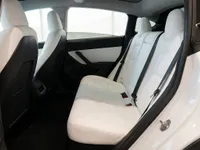 The pristine white rear interior of the Tesla Model Y in Lausanne, featuring comfortable seating and ample space.