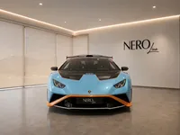The front view of the light blue and orange Lamborghini Huracán STO parked in a showroom in Lausanne.