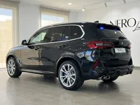 黒いBMW X5 M装甲SUVが、マドリードのショールームに駐車されており、後方3/4の角度から撮影されています。