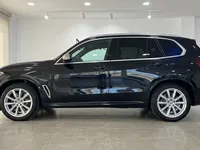 黒いBMW X5 M装甲SUVがサイドプロファイルで展示されており、マドリードのショールームでその洗練されたデザインが際立っています。