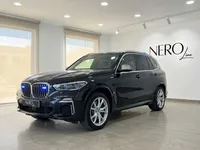 マドリードのショールームに駐車された、グリルとルーフに青い緊急灯を備えた黒いBMW X5 M装甲SUV。