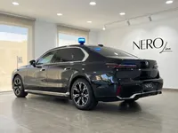 青い緊急灯を屋根に備えた黒いBMW 7 Protectionが、マドリードのショールームで後方から斜めに展示されています。