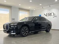 黒いBMW 7 Protectionがマドリードのショールームに展示されており、青いルーフライトとボンネットに旗が付いています。