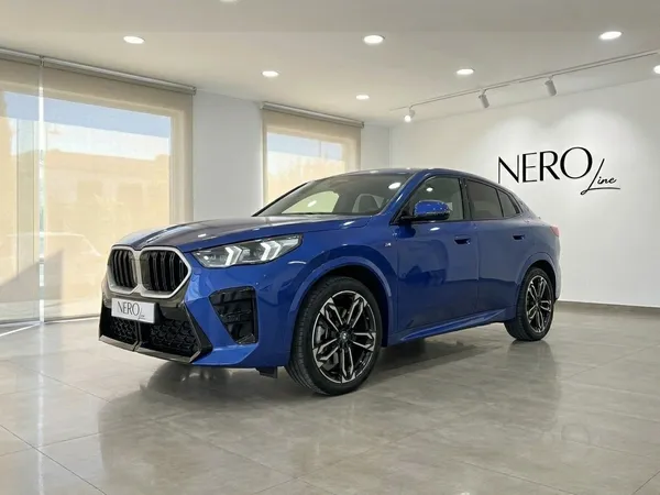 2025년형 파란색 BMW X2가 알리칸테의 쇼룸에 전면 쿼터 앵글로 눈에 띄게 전시되어 있습니다.