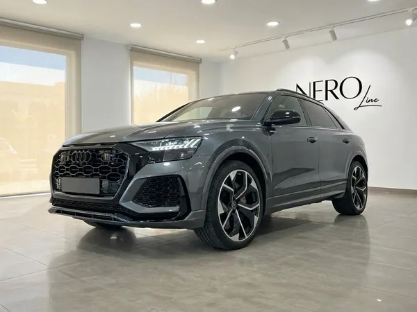 The metallic gray Audi RS Q8 performance SUV is showcased from a front three-quarter view in a bright showroom in Alicante.