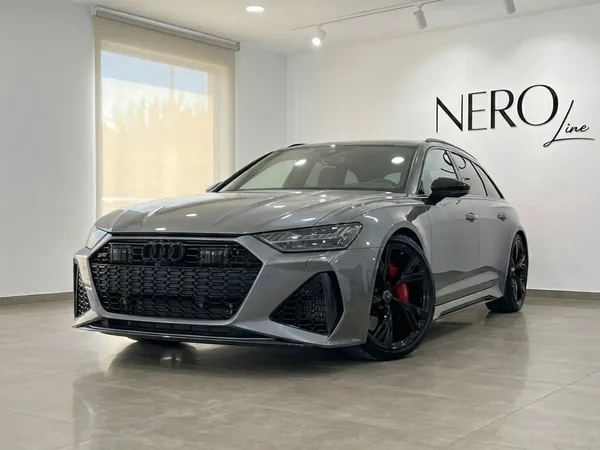 The metallic gray 2025 Audi RS6 Performance is showcased in a showroom, captured from a front three-quarter angle in Marbella.