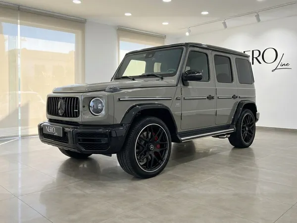 光沢のあるアラビアングレーのメルセデス・ベンツG63 AMGが、イビサの屋内に駐車され、前部3/4の角度から見えます。